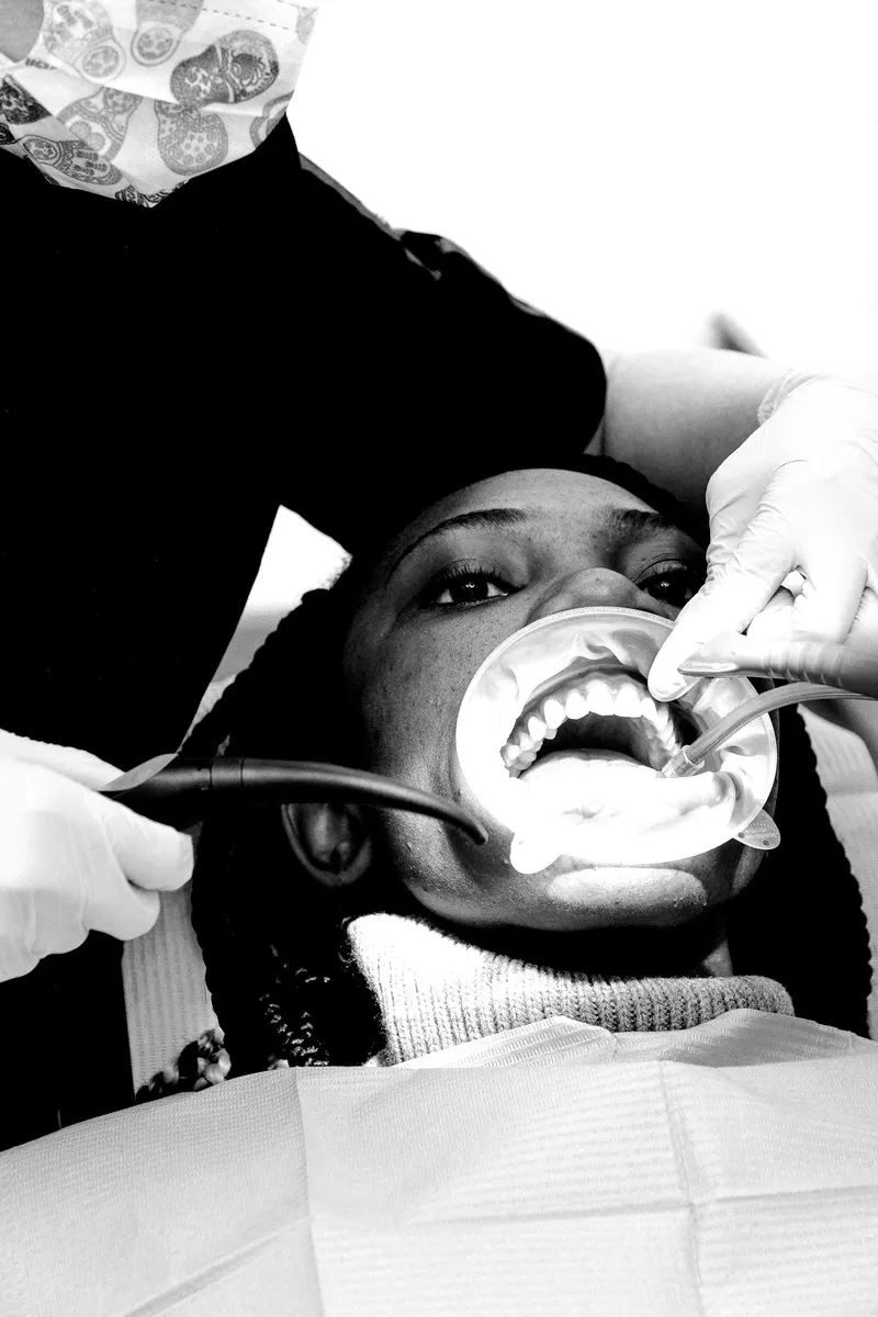 Dentists performing treatment on a patient under a dental light