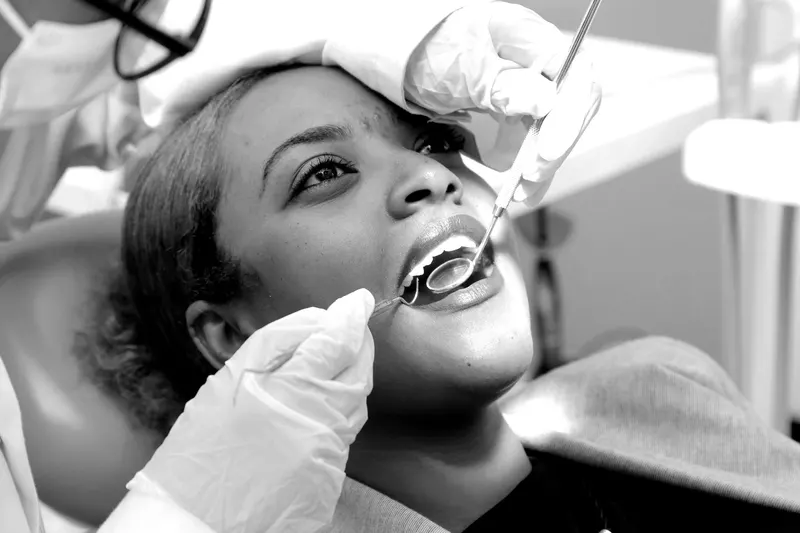 Dentist examining a patient’s teeth with a mirror and probe